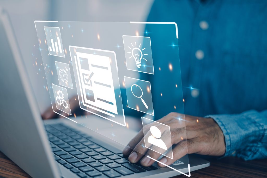 A person using a laptop with icons representing content creation superimposed above it.